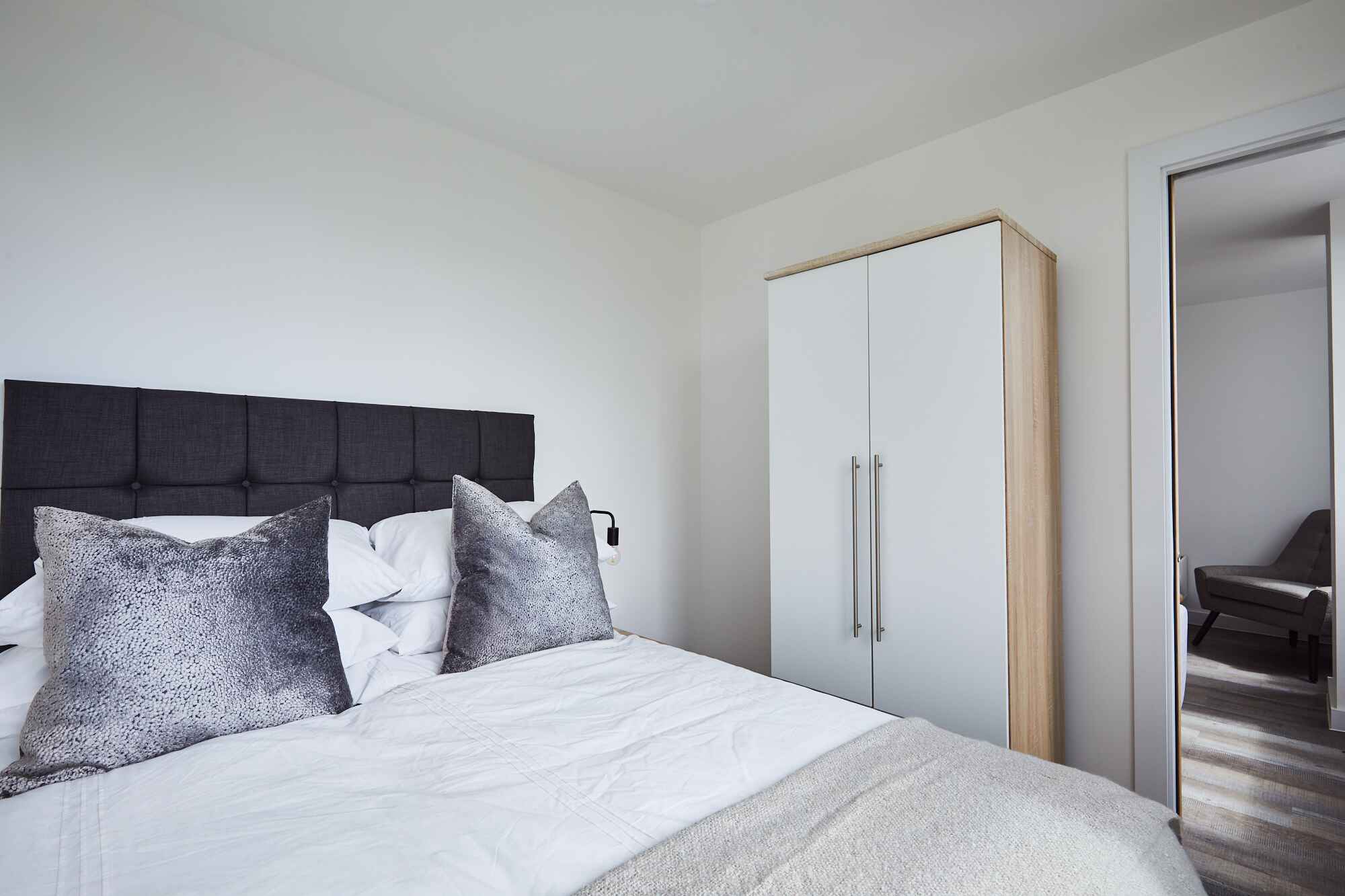 Kinetic bedroom featuring bed with white wardrobe
