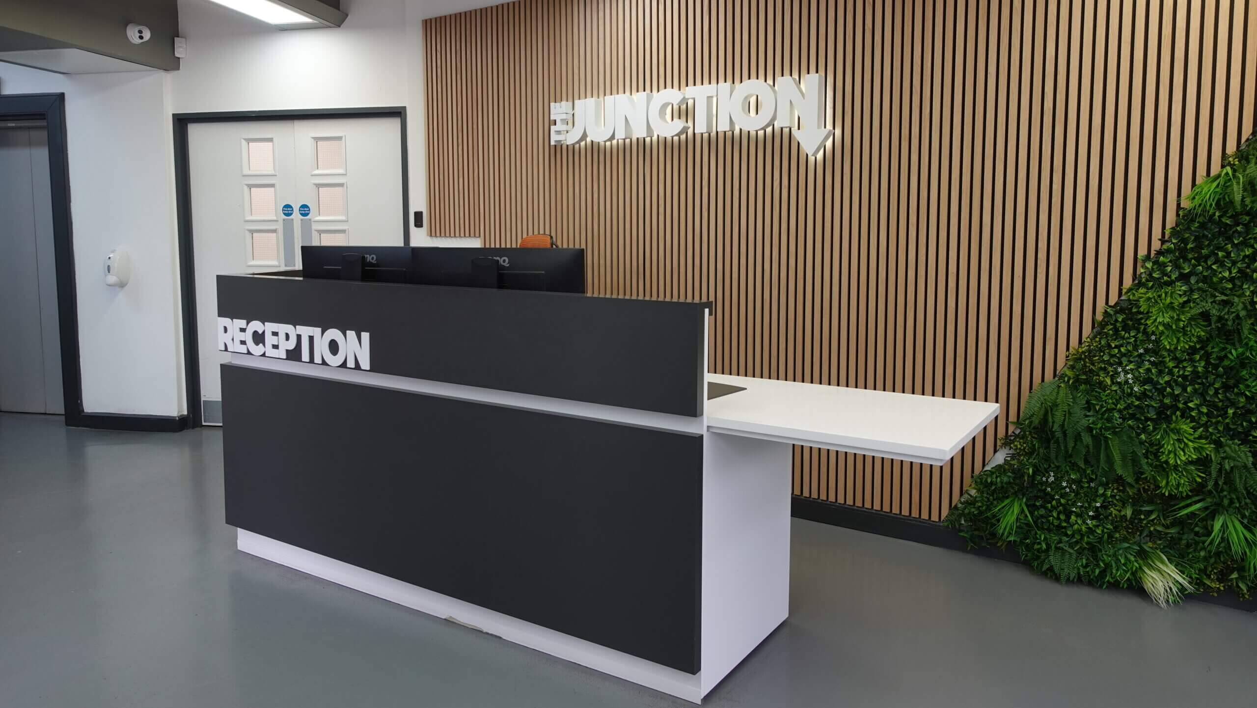 The Junction reception with the office logo on the wall behind the reception desk