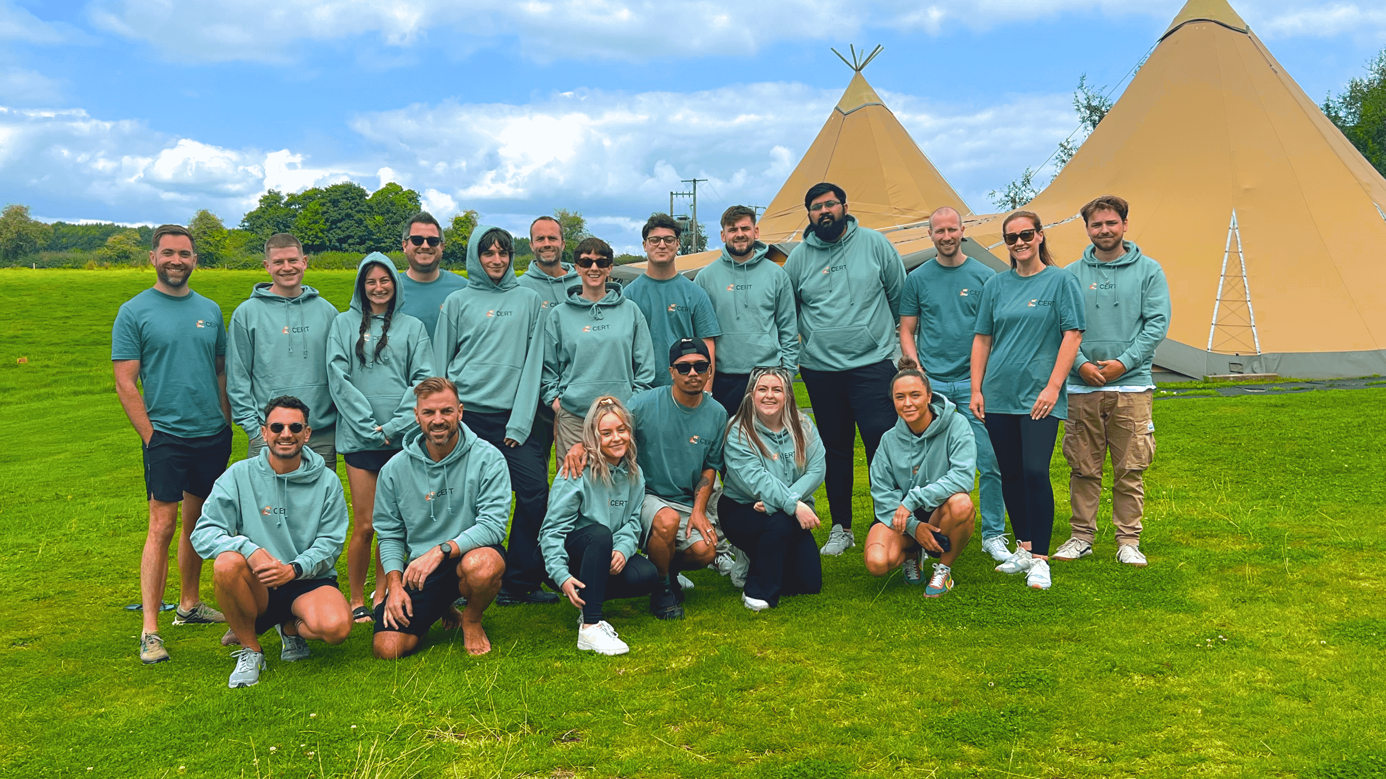 CERT team group wearing matching green CERT jumpers outside tipi tents