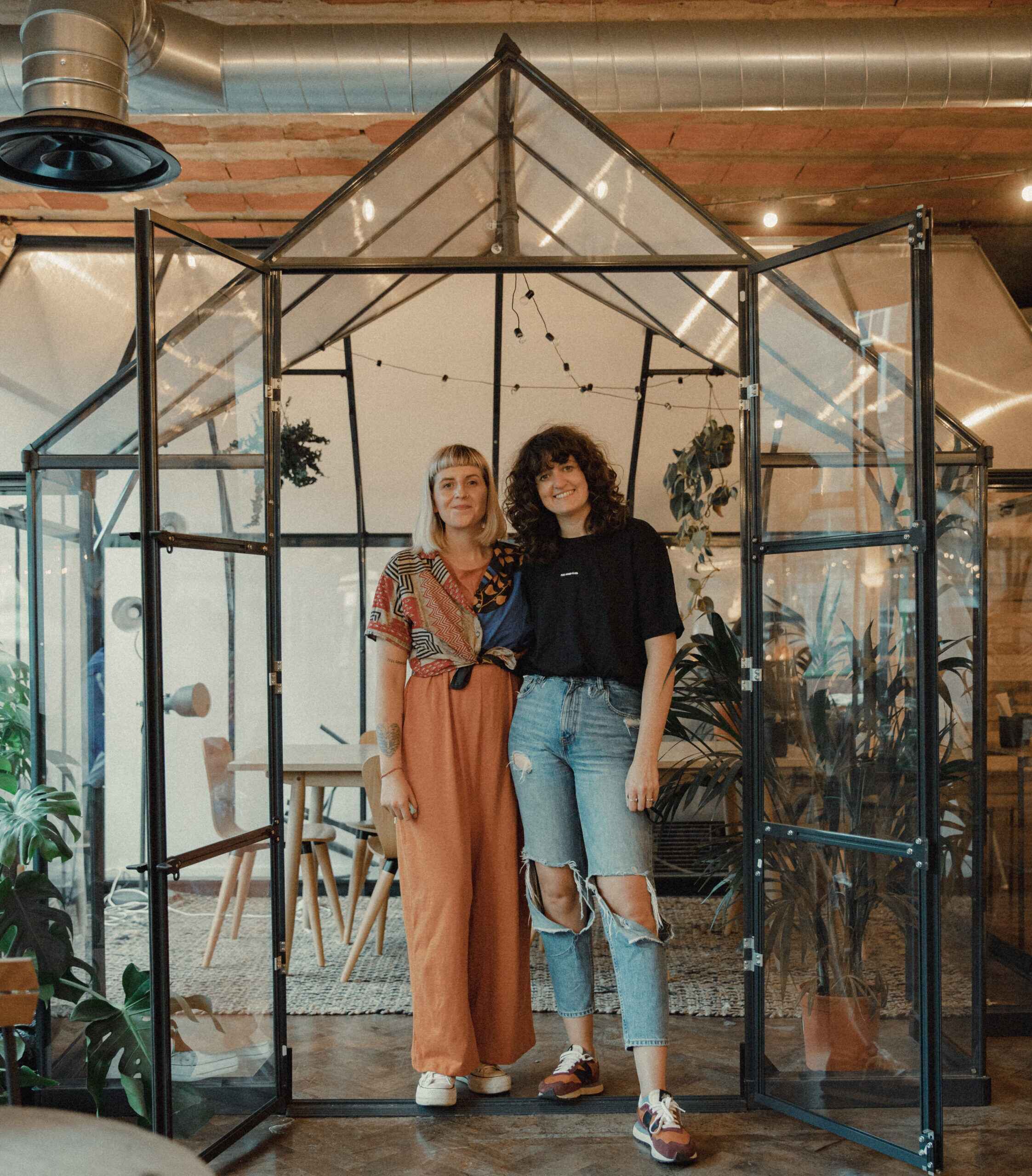 Keira and Aimie in front of the greenhouse in feel good club Health and Wellbeing Cafe, manchester